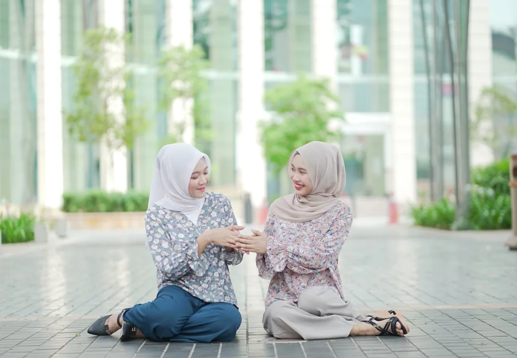 Two professionals talking outside a modern office building in Kuala Lumpur.